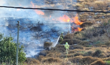 رجال الإطفاء يقومون بإخماد حريق في منطقة مفتوحة في حيفا